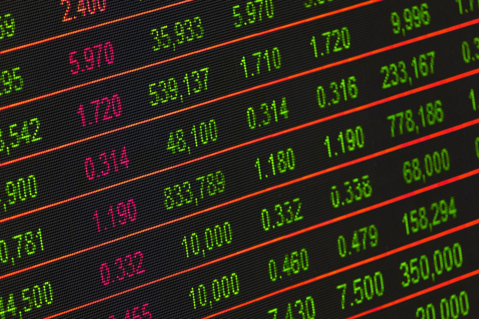 Notas de real, calculadora e moedas sobre uma mesa, ilustrando comparação financeira entre investimentos.