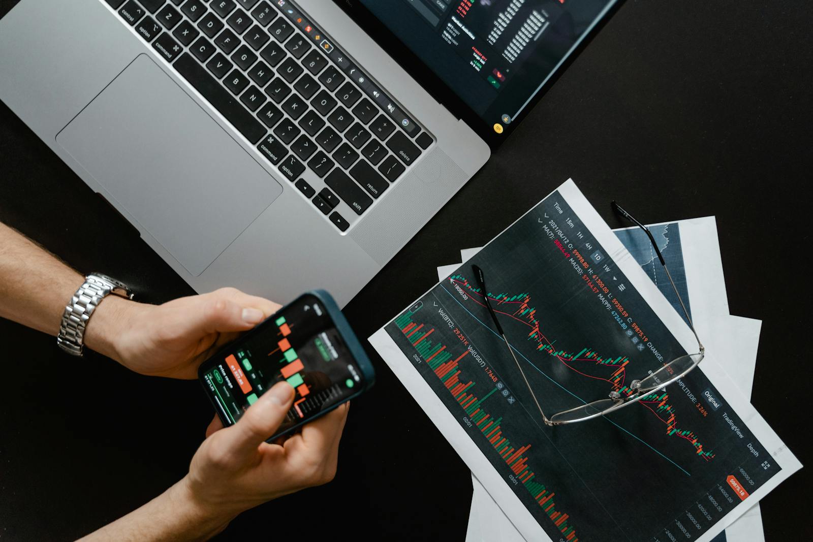 Pessoa trabalhando em laptop com gráficos e análises financeiras na tela.